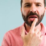 Un homme pointe ses lèvres avec son index car il souffre de bouche sèche