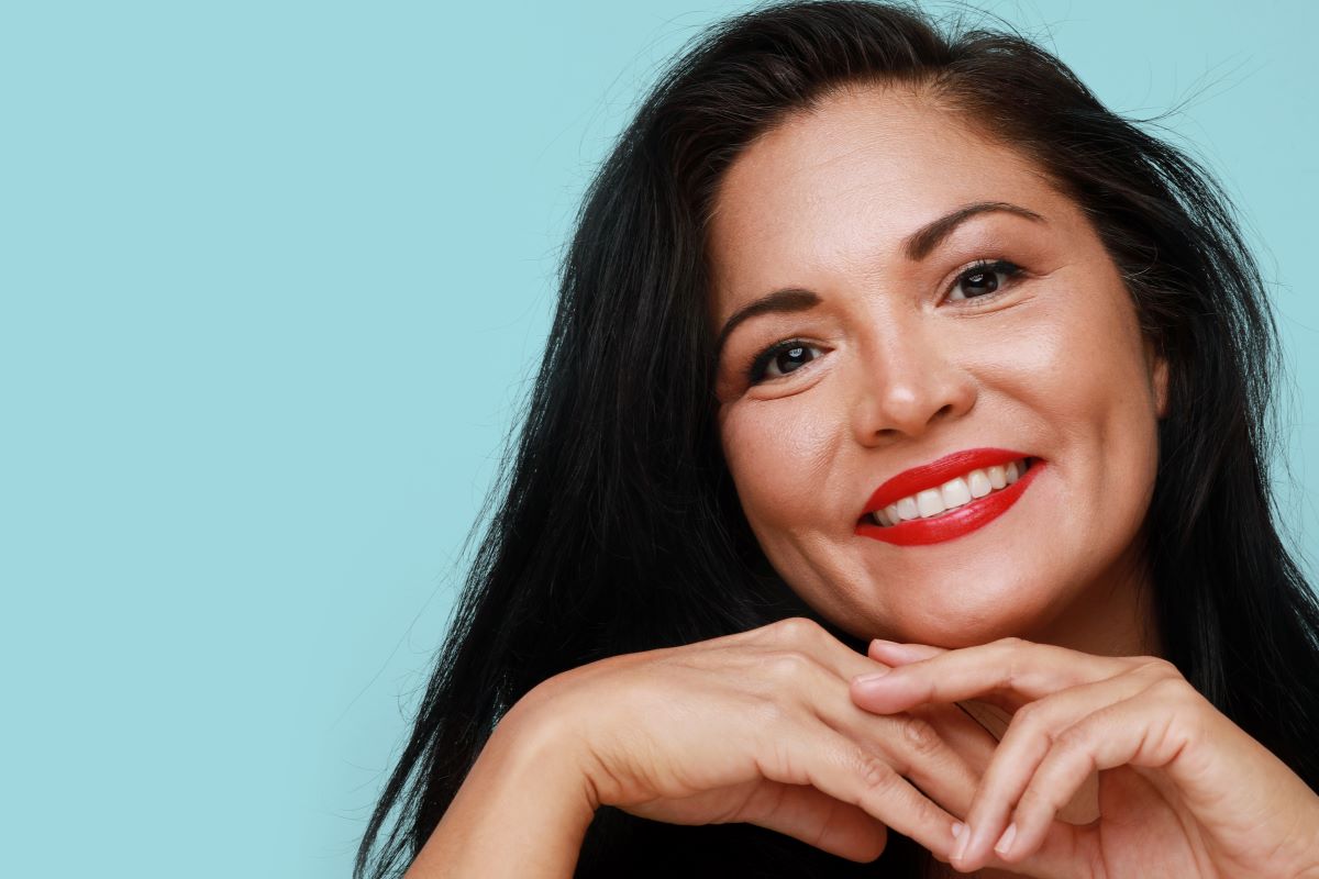 Une femme sourit, laissant apparaître ses facettes dentaires.