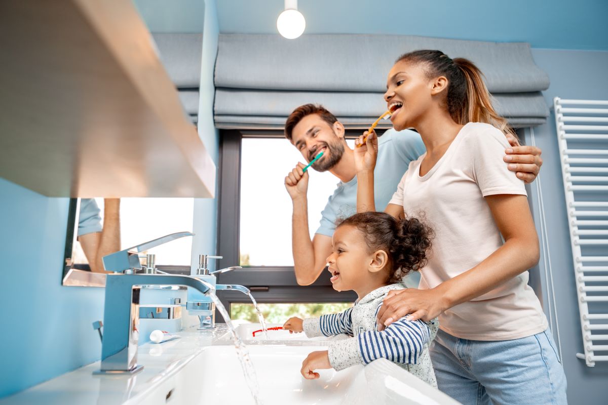 Une jeune famille se brosse les dents avec un dentifrice choisi au préalable.